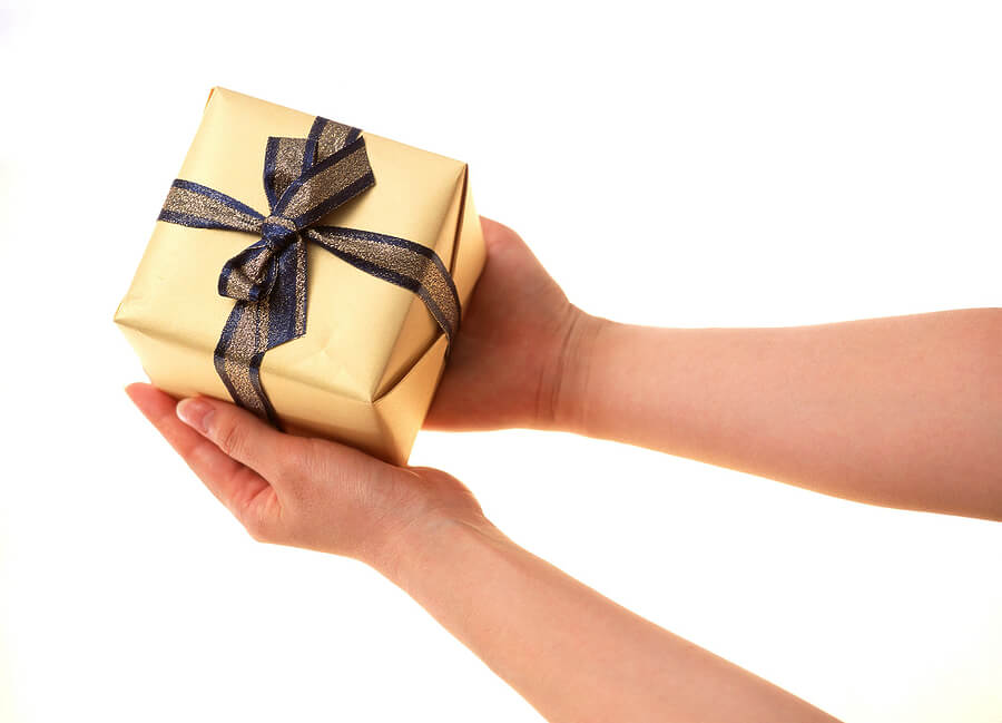 Holding a small wrapped gift box
