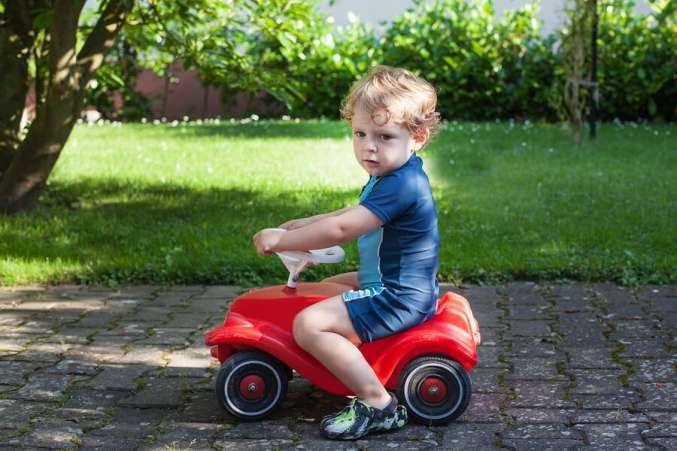 boy riding toy car