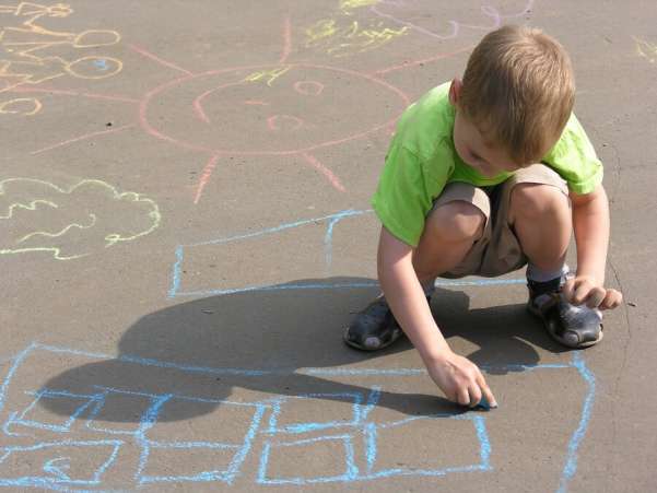 child drawing with sidewalk chalk